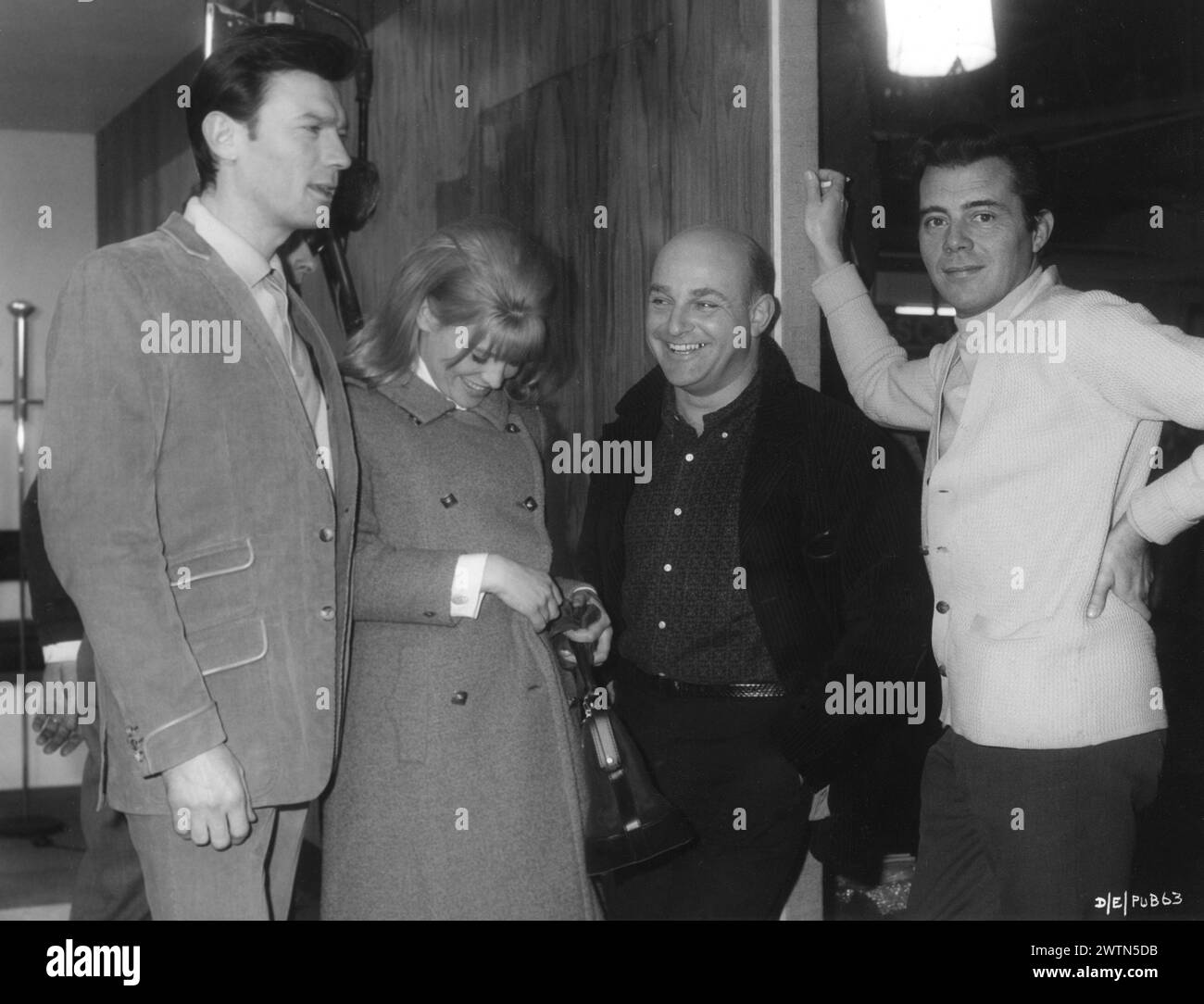 A candid photo of British Actress JULIE CHRISTIE with LAURENCE HARVEY, JOHN SCHLESINGER and DIRK BOGARDE on the set of DARLING 1965  Director JOHN SCHLESINGER  Screenplay FREDERIC RAPHAEL Costume Design JULIE HARRIS Music JOHN DANKWORTH Vic-Appia Films / Anglo Amalgamated Stock Photo