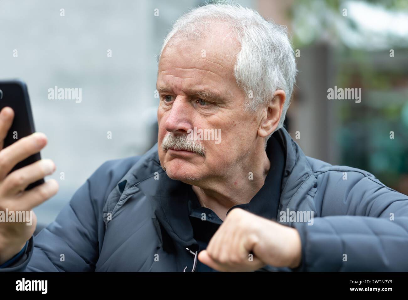 Senior man looking confused at mobile phone. Stock Photo