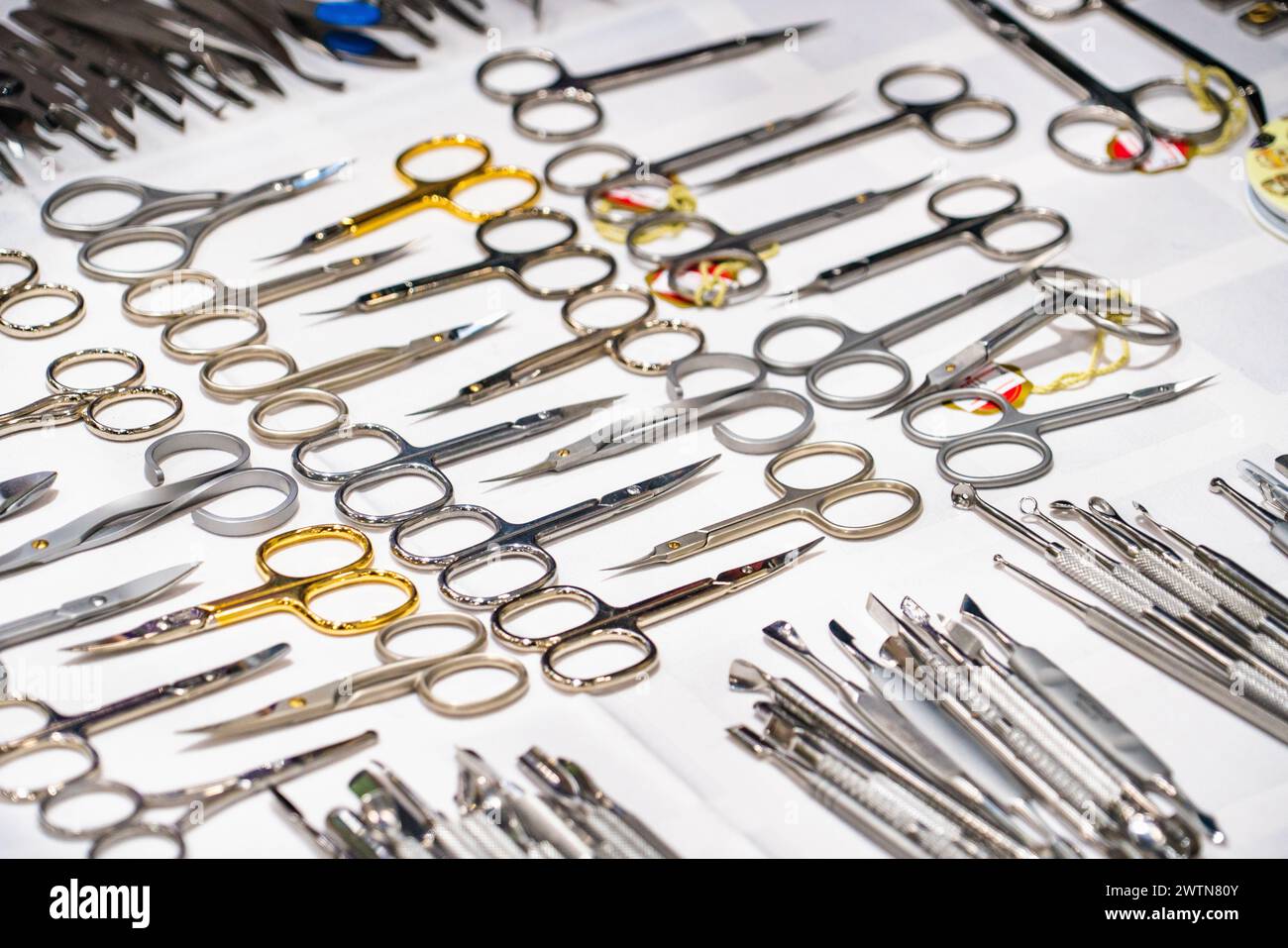 Set of many different scissors for manicure. Metal scissors on a white background. Close-up.. Stock Photo