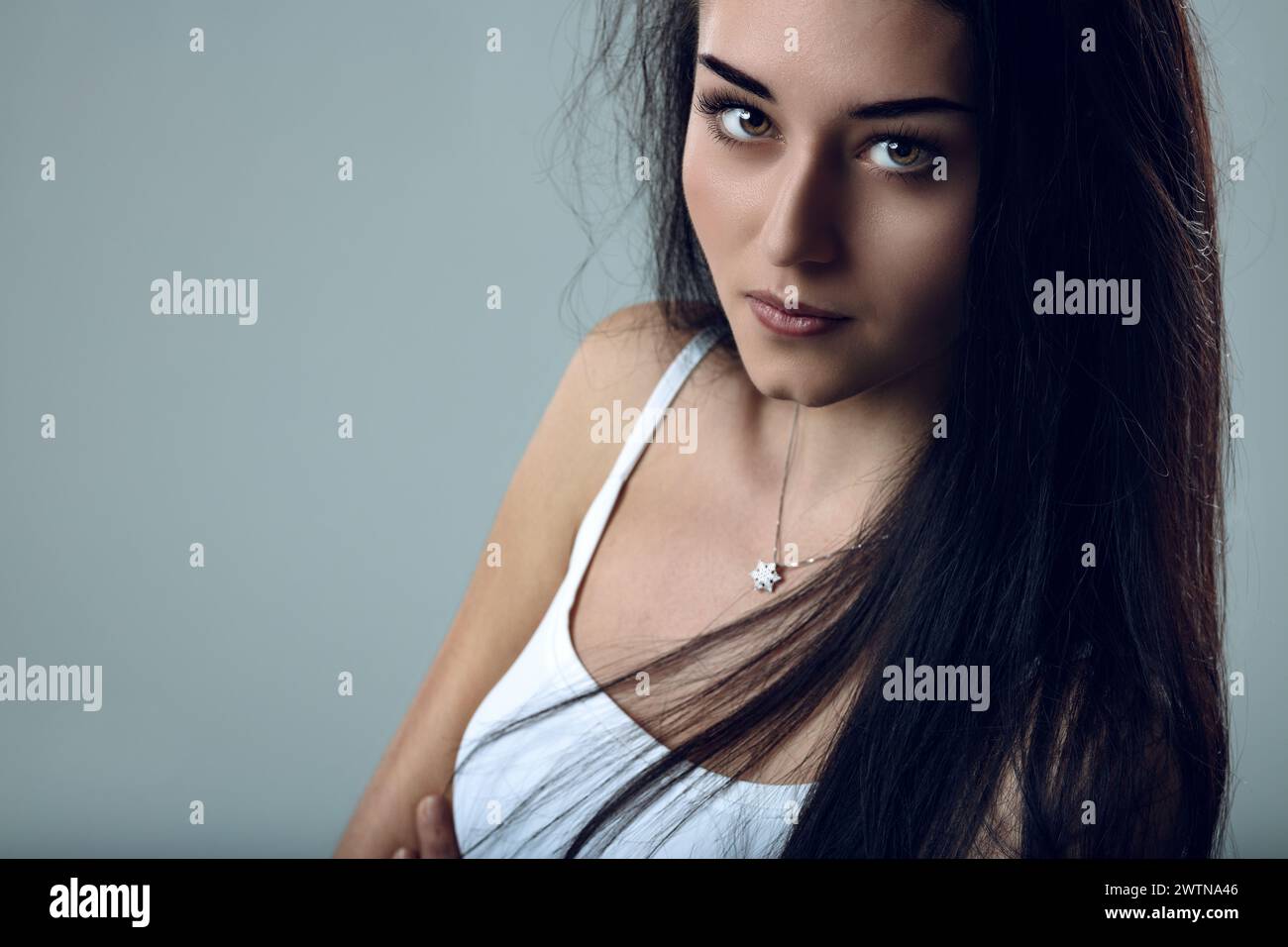 Dark-haired beauty presents a mix of warmth and mystique Stock Photo