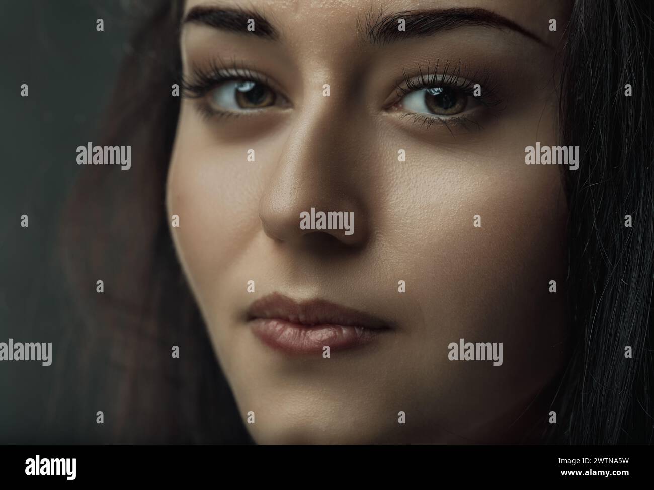 Dark hair frames her contemplative face, eyes that invite stories Stock Photo