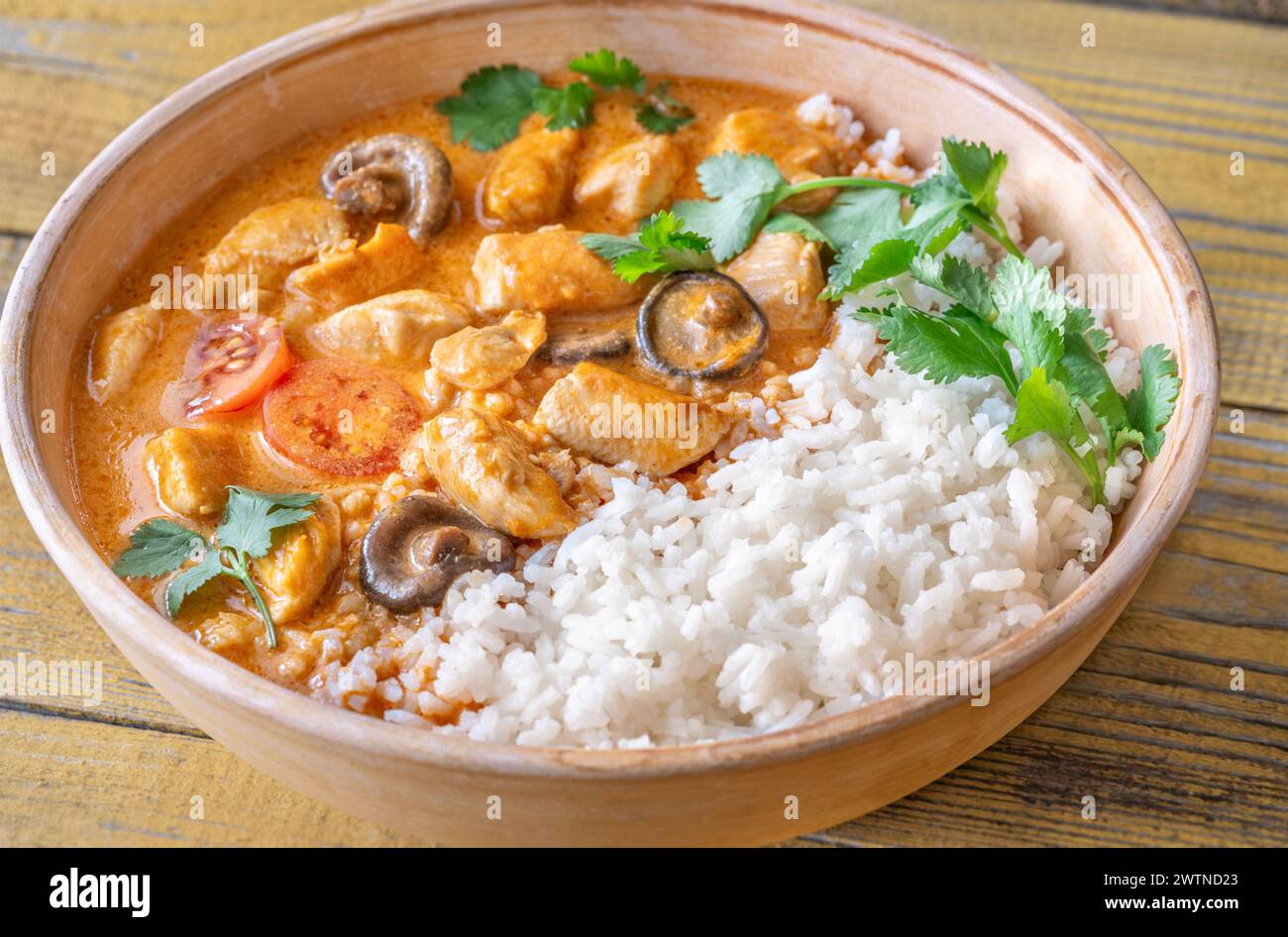 Bowl of chicken red curry on wooden background Stock Photo