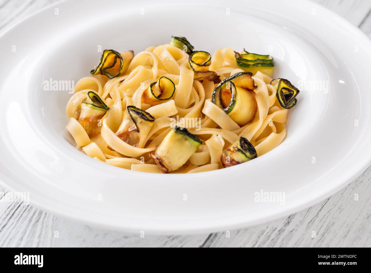 Portion of zucchini parmesan tagliatelle pasta in plate Stock Photo