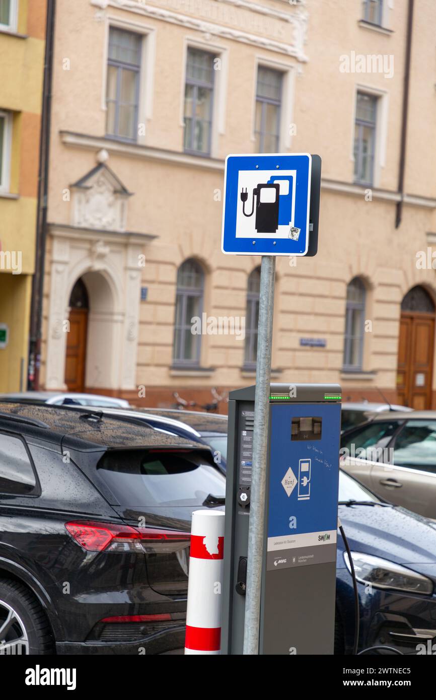 Munich, Germany - DEC 25, 2021: Electric car charging from Munich's public charging station provided by SWM, owned by the city of Munich. Stock Photo