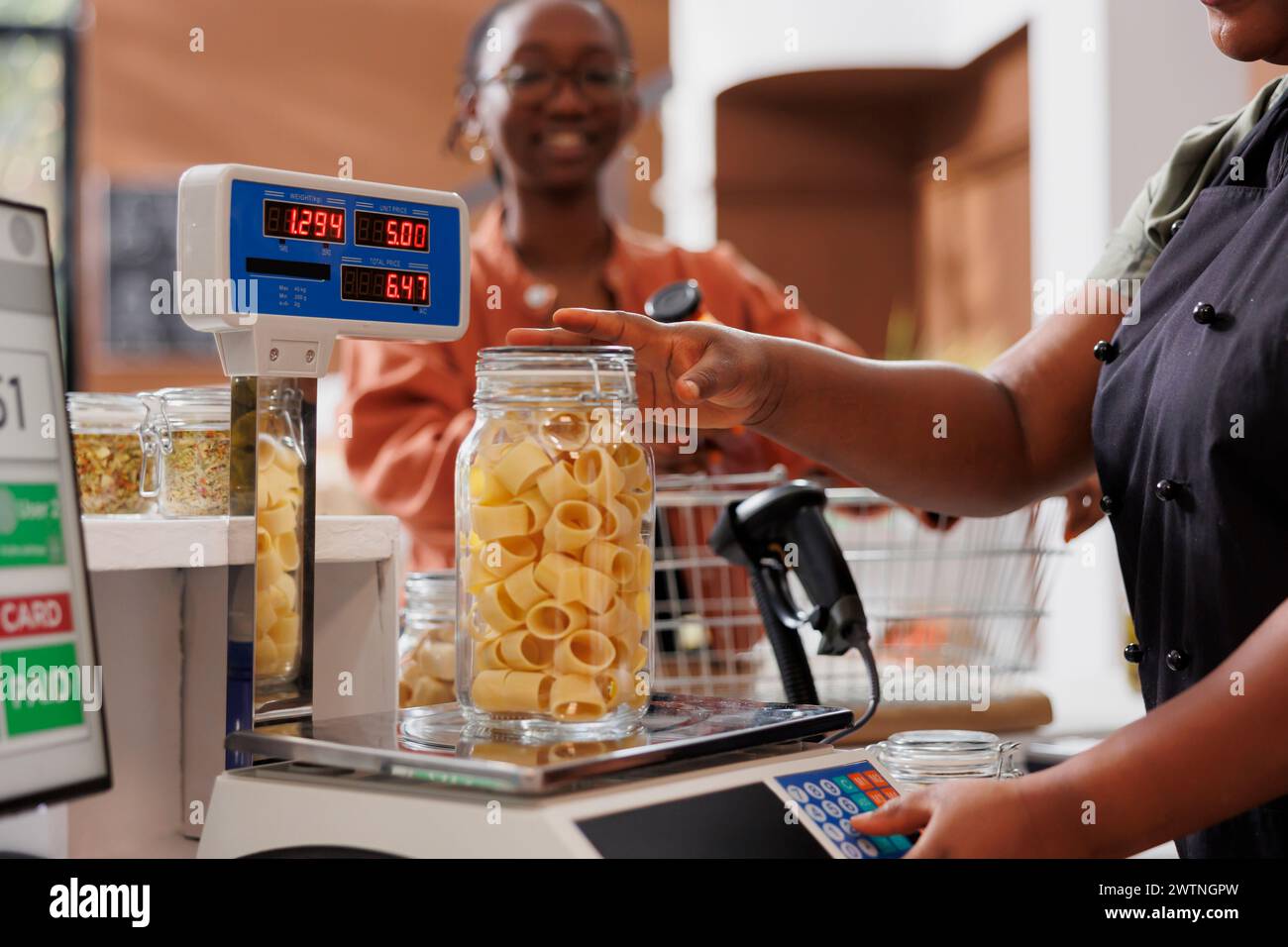 Black woman with spectacles waiting while vendor uses digital scale to