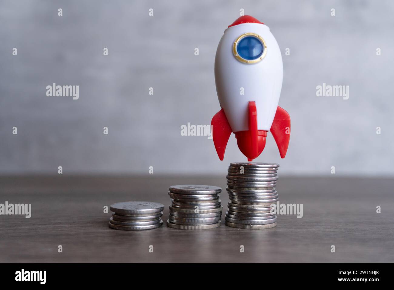 Closeup image of rocket spaceship and coins. Business startup, launch and boost concept. Stock Photo