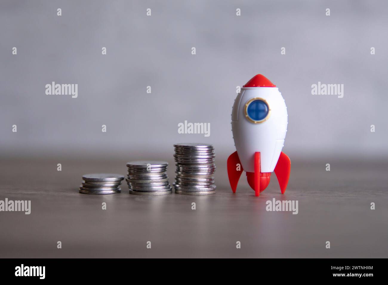 Closeup image of rocket spaceship and coins. Business startup, launch and boost concept. Stock Photo