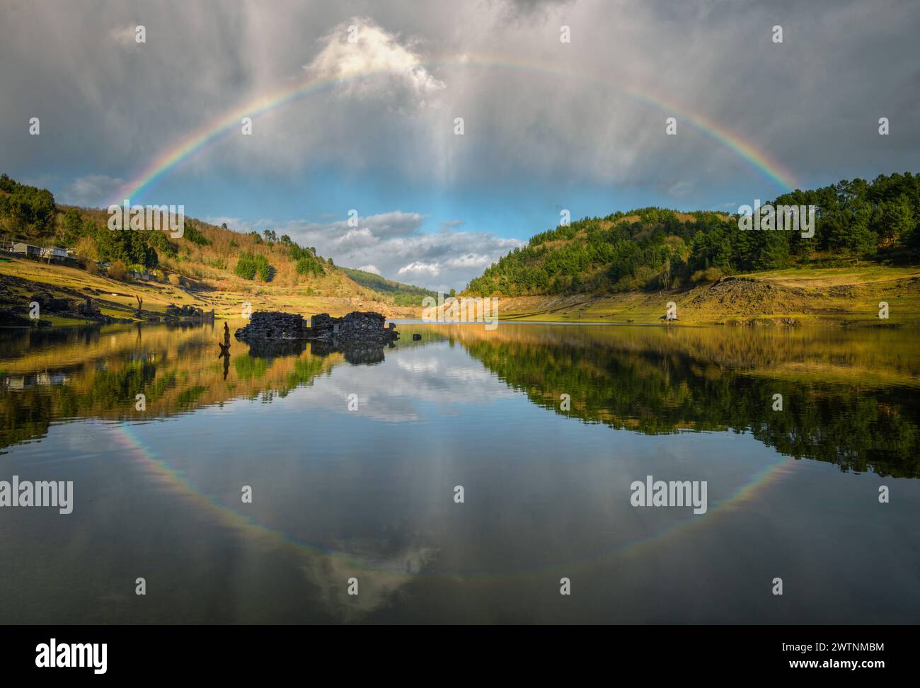 A complete rainbow and its reflection in the river near Portomarin Lugo Galicia Stock Photo