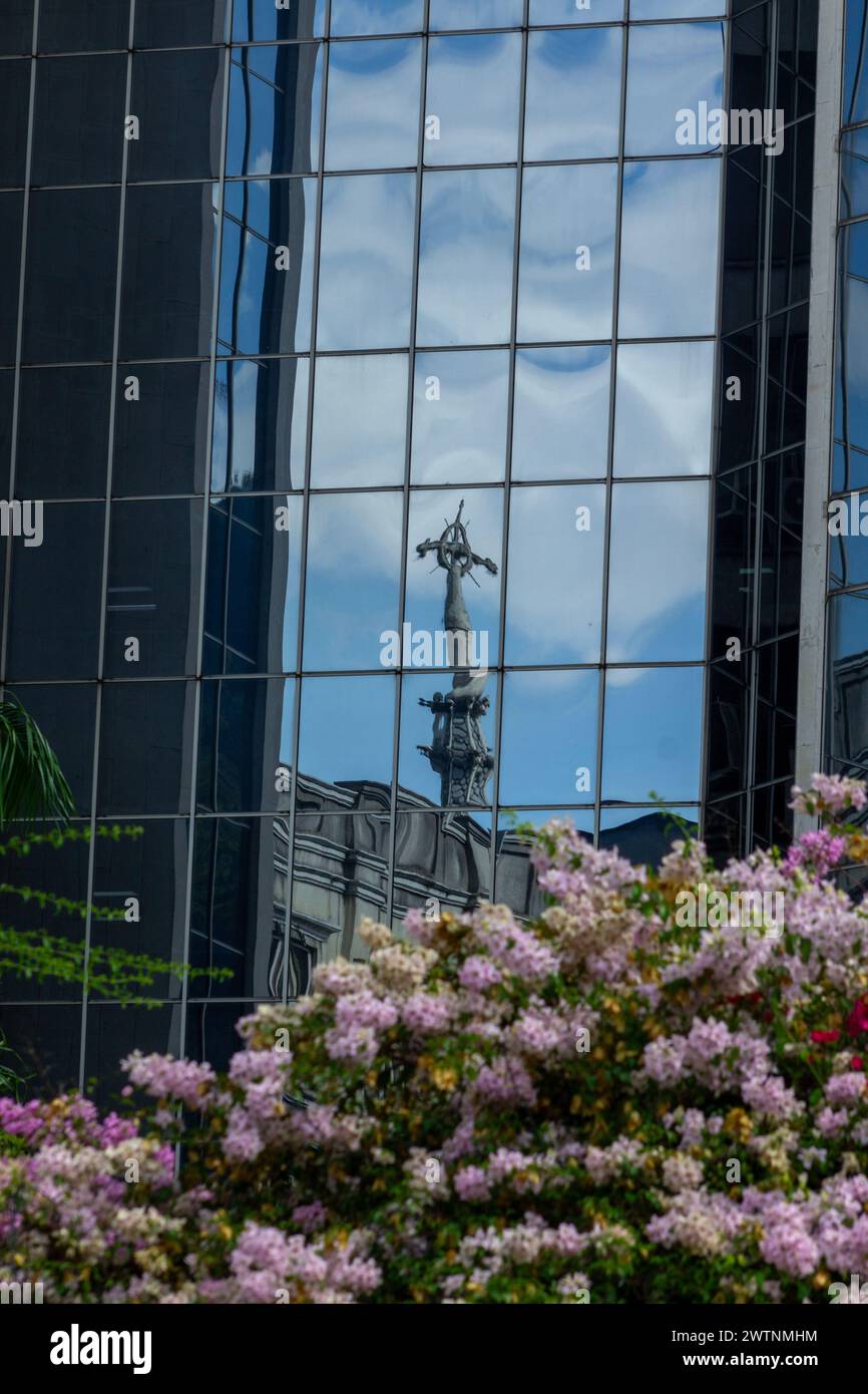 View of the reflection of the cross of La Ermita church on the windows of a building Stock Photo