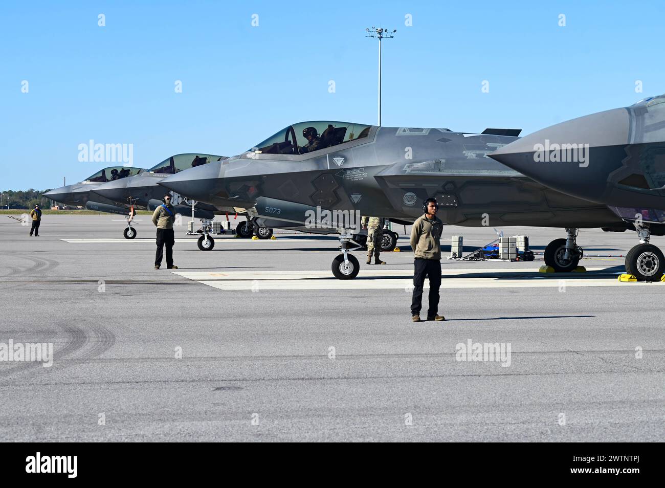 U.S. Air Force crew chiefs assigned to the 58th Aircraft Maintenance Unit prepare to marshal F-35A Lightning II aircraft on the flightline at MacDill Air Force Base, Florida, Feb. 26, 2024. The 58th AMU accomplished hot pit refuels and rapid pilot swaps through multi-capable airmen operations while at MacDill. (U.S. Air Force photo by Senior Airman Briana Beavers) Stock Photo