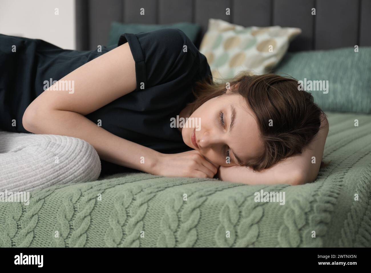 Sad young woman lying on bed at home Stock Photo - Alamy
