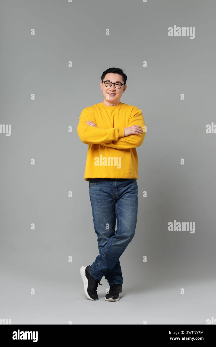 Full length portrait of happy man on grey background Stock Photo - Alamy