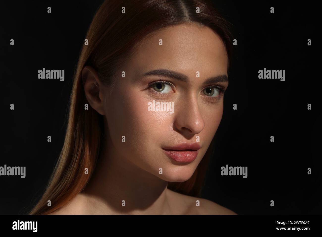 Evil eye. Young woman with scary eyes on black background Stock Photo