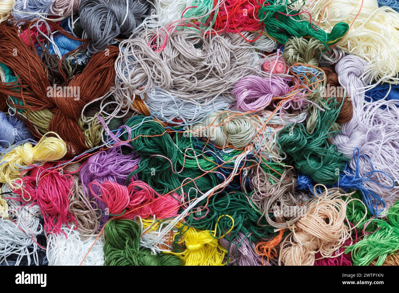 A pile of tangled multi-colored threads, close-up, top view. Abstract ...