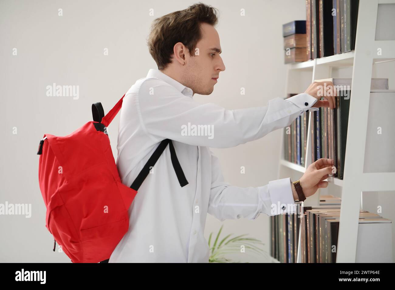 Male student choosing book in library Stock Photo