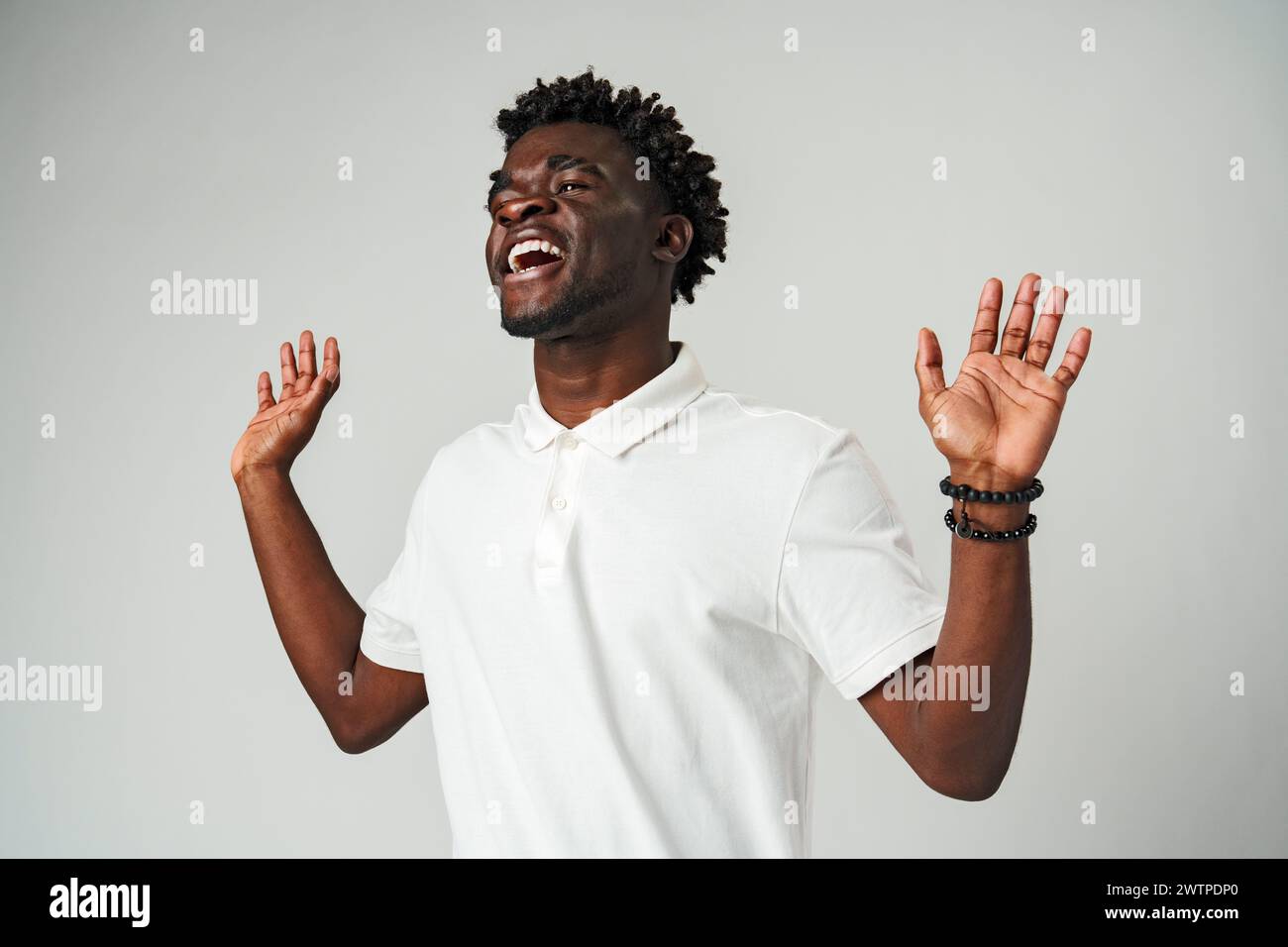 Young African Man Standing With Hands Raised Stock Photo - Alamy