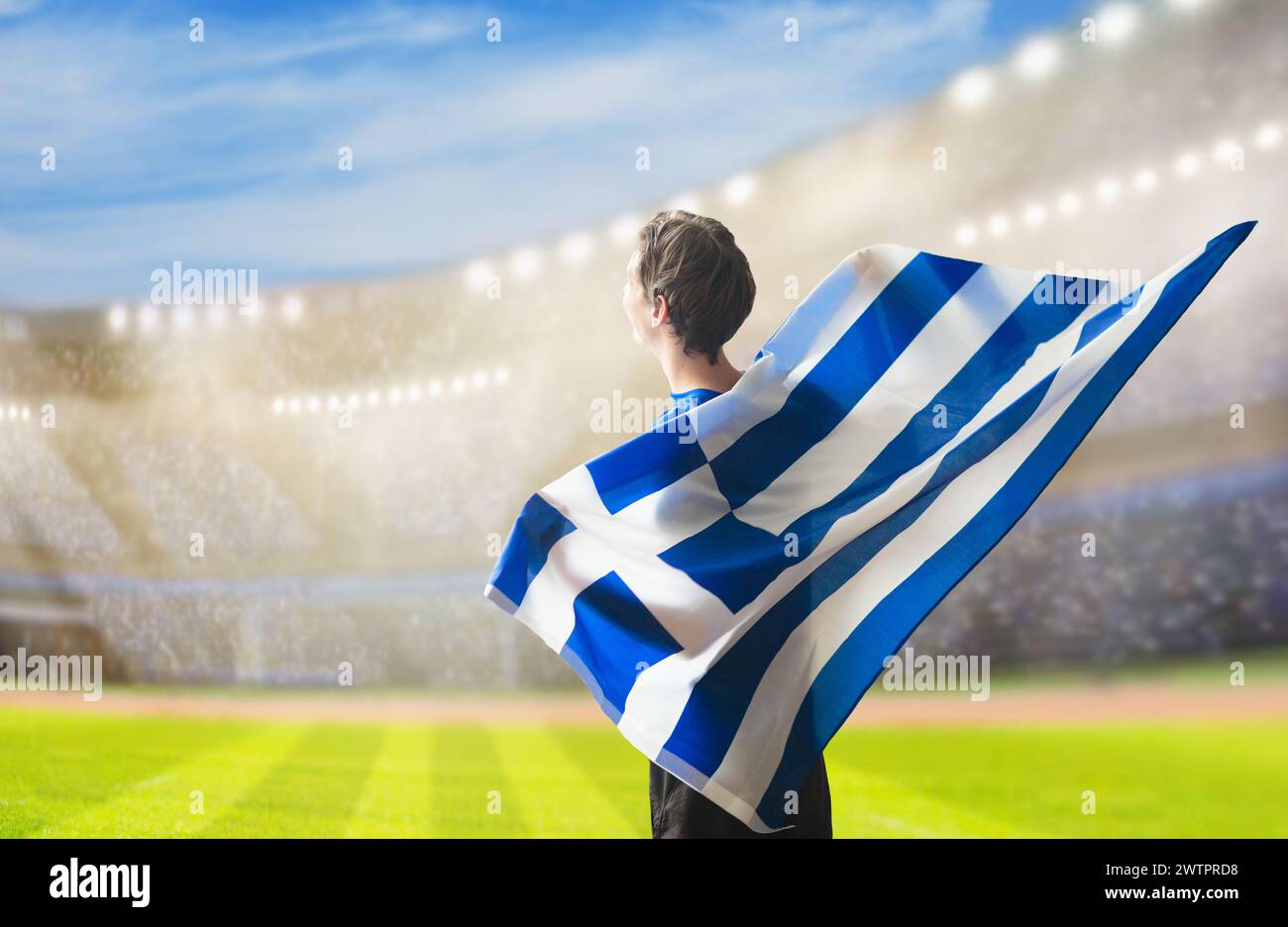 Greece football supporter on stadium. Greek fans on soccer pitch watching team play. Group of supporters with flag and national jersey cheering Stock Photo