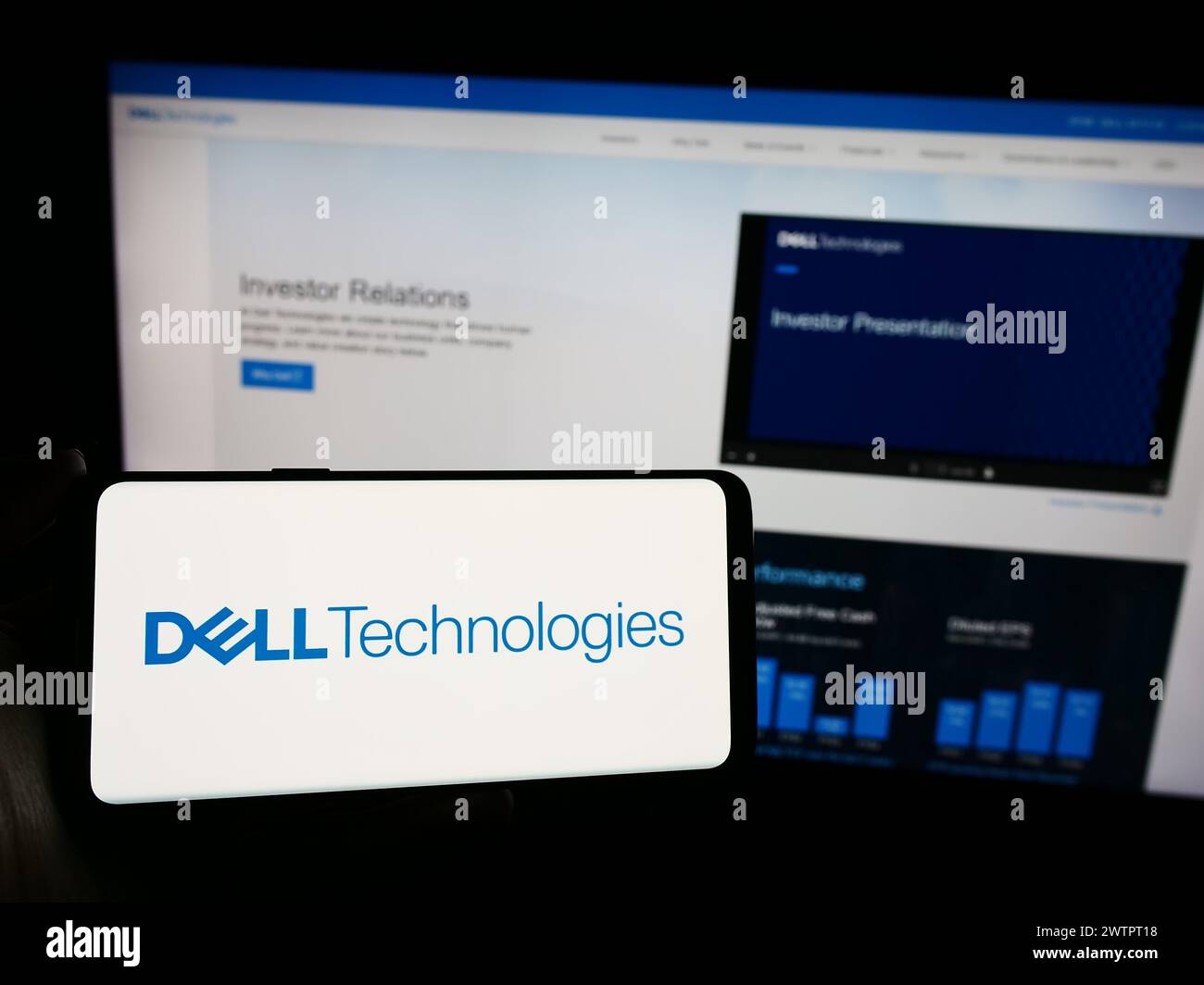 Person holding smartphone with logo of US technology company Dell Technologies Inc. in front of website. Focus on phone display. Stock Photo