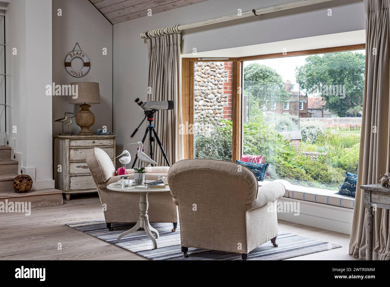 Telescope in picture window with view of coastal Blakeney, Norfolk, UK Stock Photo