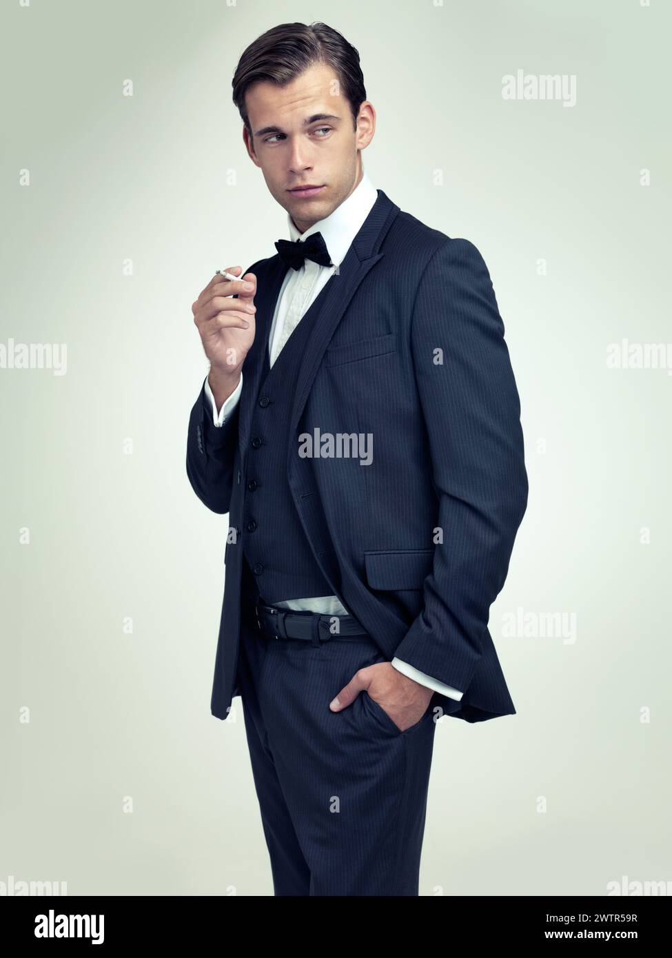 Fashion gentleman and tuxedo with cigarette in studio for stylish trend and habit with suit and luxury. Young person and stare with confidence for Stock Photo Alamy