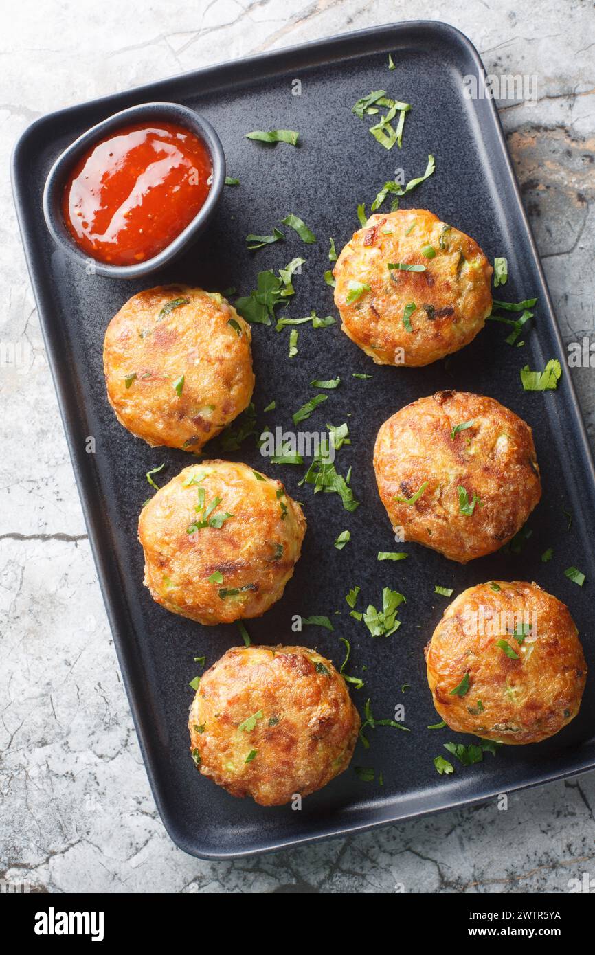 Perkedel Kentang Indonesian style potato patties with sauce closeup on the plate on the table. Vertical top view from above Stock Photo
