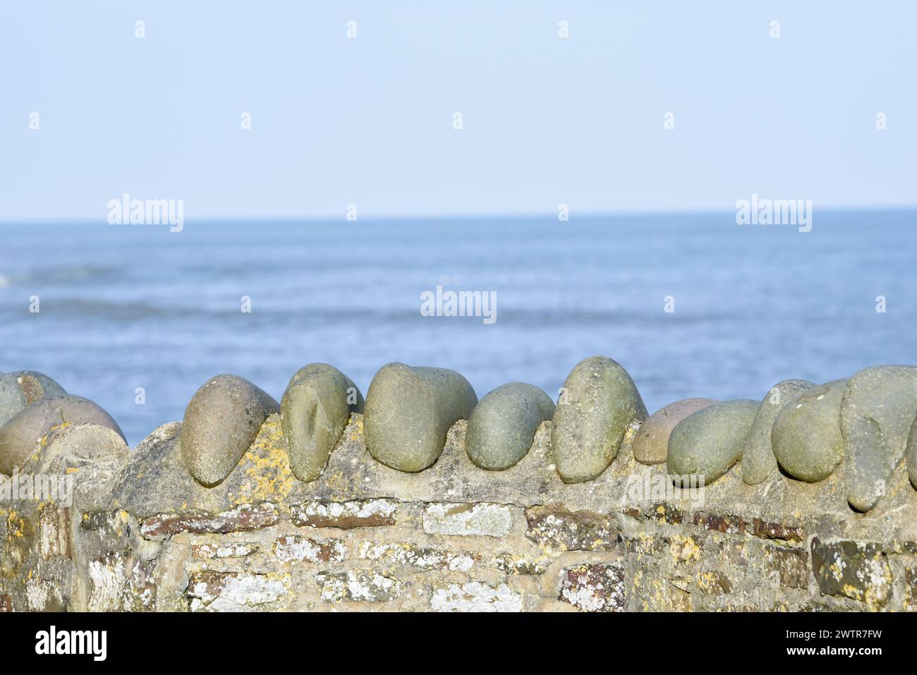 Stone sea wall with a clear view out over the ocean Stock Photo