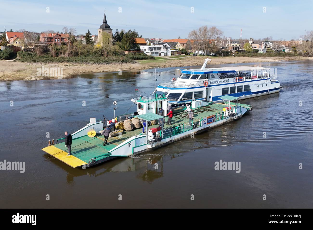 Magdeburg, Germany. 19th Mar, 2024. The excursion ship 'Sachsen Anhalt' of the Weisse Flotte Magdeburg keeps the yaw ferry 'Westerhüsen' in position on the Elbe so that employees can replace around 350m of steel cables. After around five years of continuous use, the employees are now replacing around 350m of steel cables and the buoys are being checked by the TÜV. The ferry, which dates back to 1933, is an important link to the Elbe cycle path in Saxony-Anhalt. Credit: Peter Gercke/dpa-Zentralbild/ZB/dpa/Alamy Live News Stock Photo