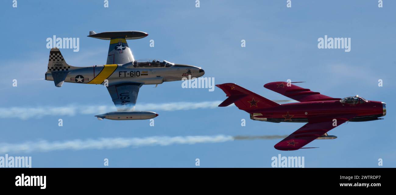 A T-33 assigned to Ace Maker Airshows, left, and a MiG-17, flown by Jason Somes, perform aerobatic maneuvers together during the Travis Air Force Base Stock Photo