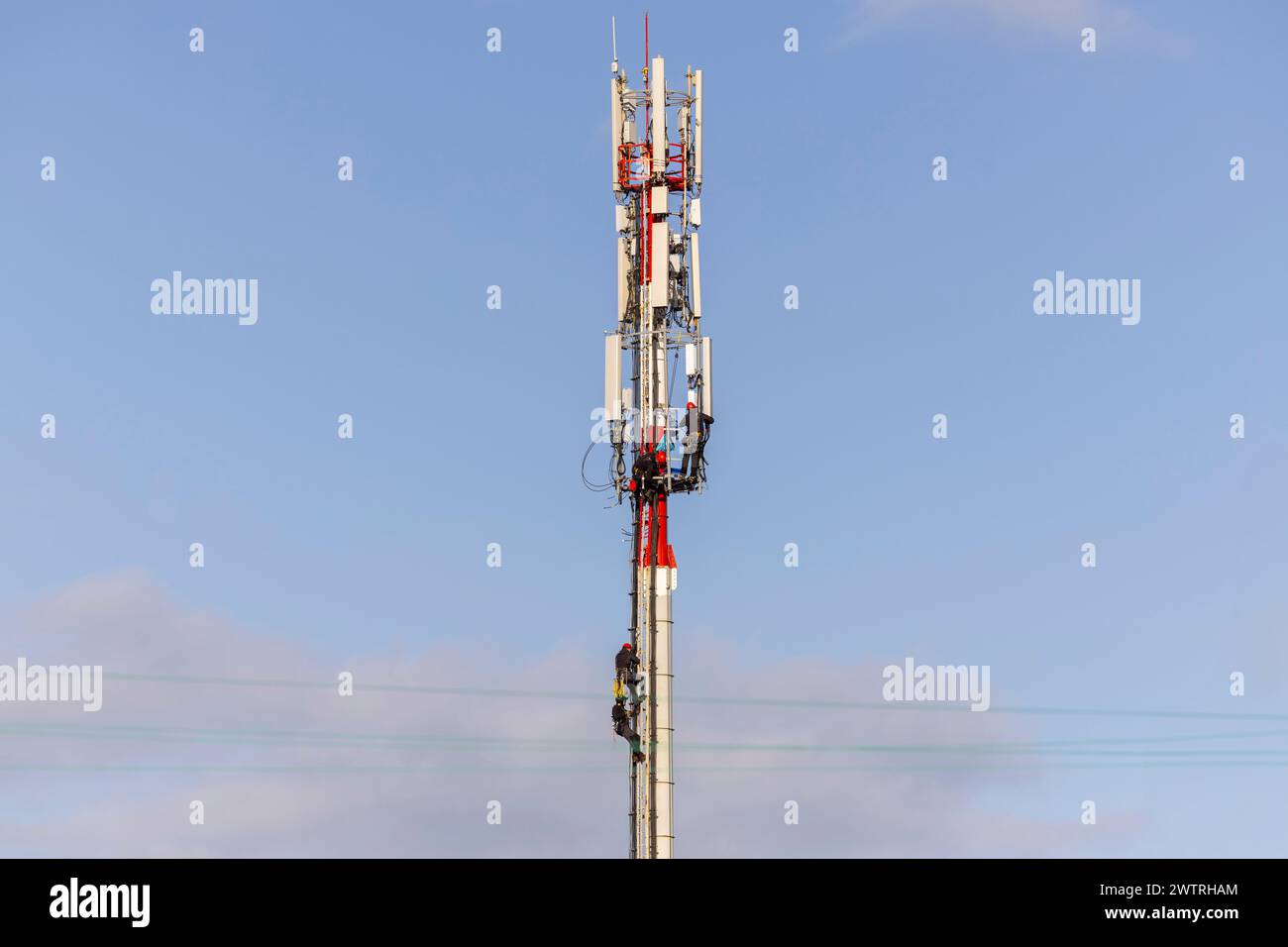 Technicians assembling antennas for 5G cellular communication on a telecommunications tower. Base Station or Base Transceiver Station. Stock Photo