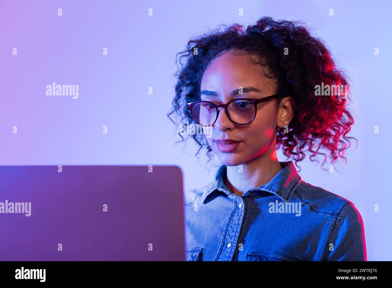 Focused young woman working on laptop Stock Photo