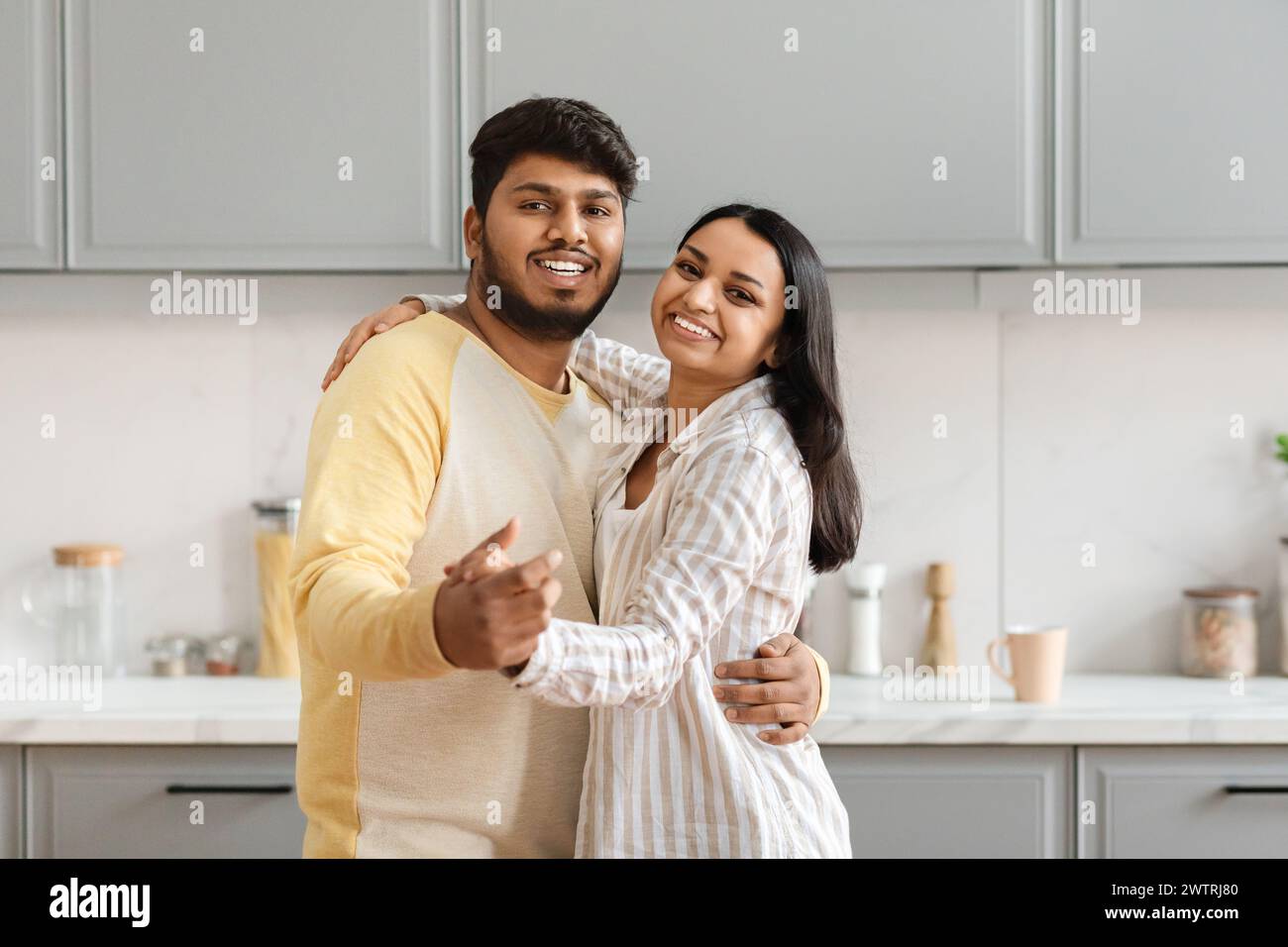 Loving young indian couple dancing in kitchen Stock Photo