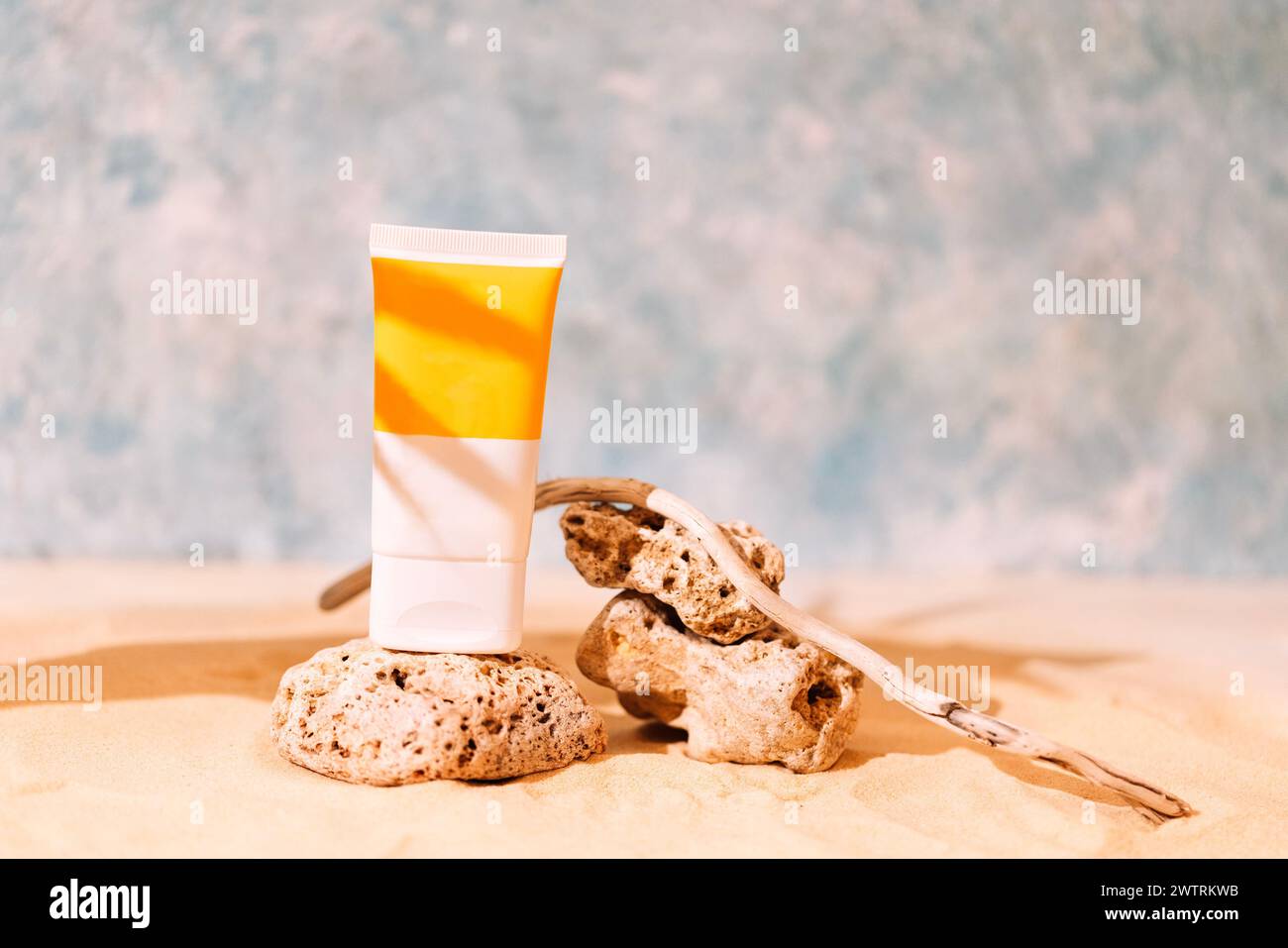 Mockup tubes with sunscreen on textured stones with a tree root. A ...