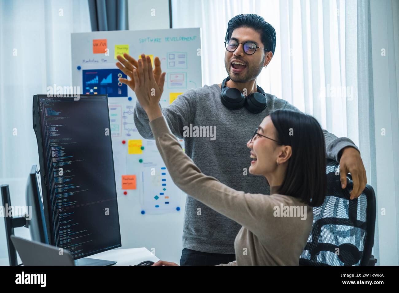 asian and Indian Developer team clapping hand for project success  with software computer at office Stock Photo