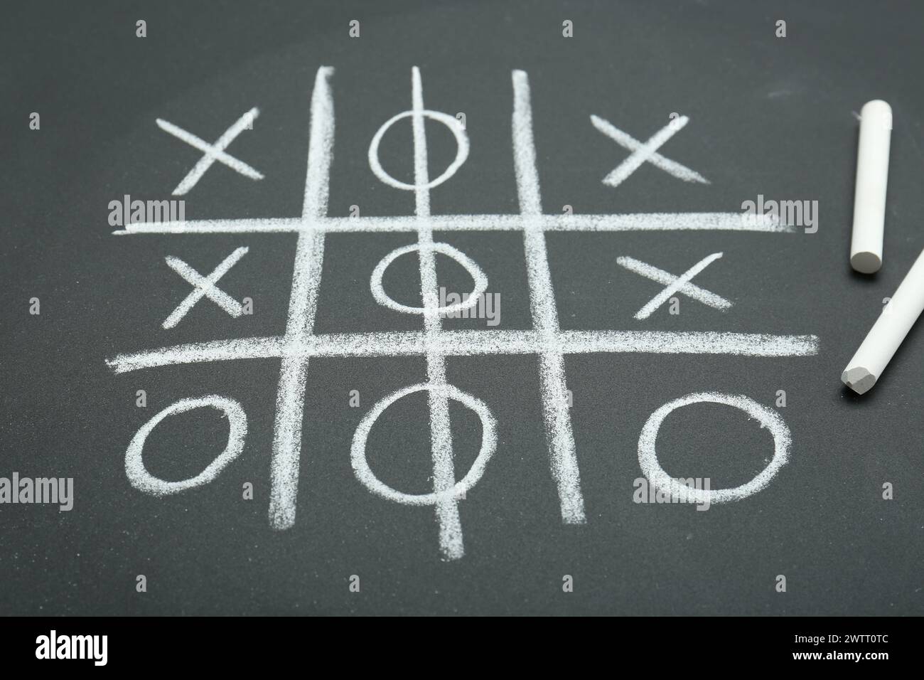 Tic tac toe game drawn on chalkboard Stock Photo - Alamy