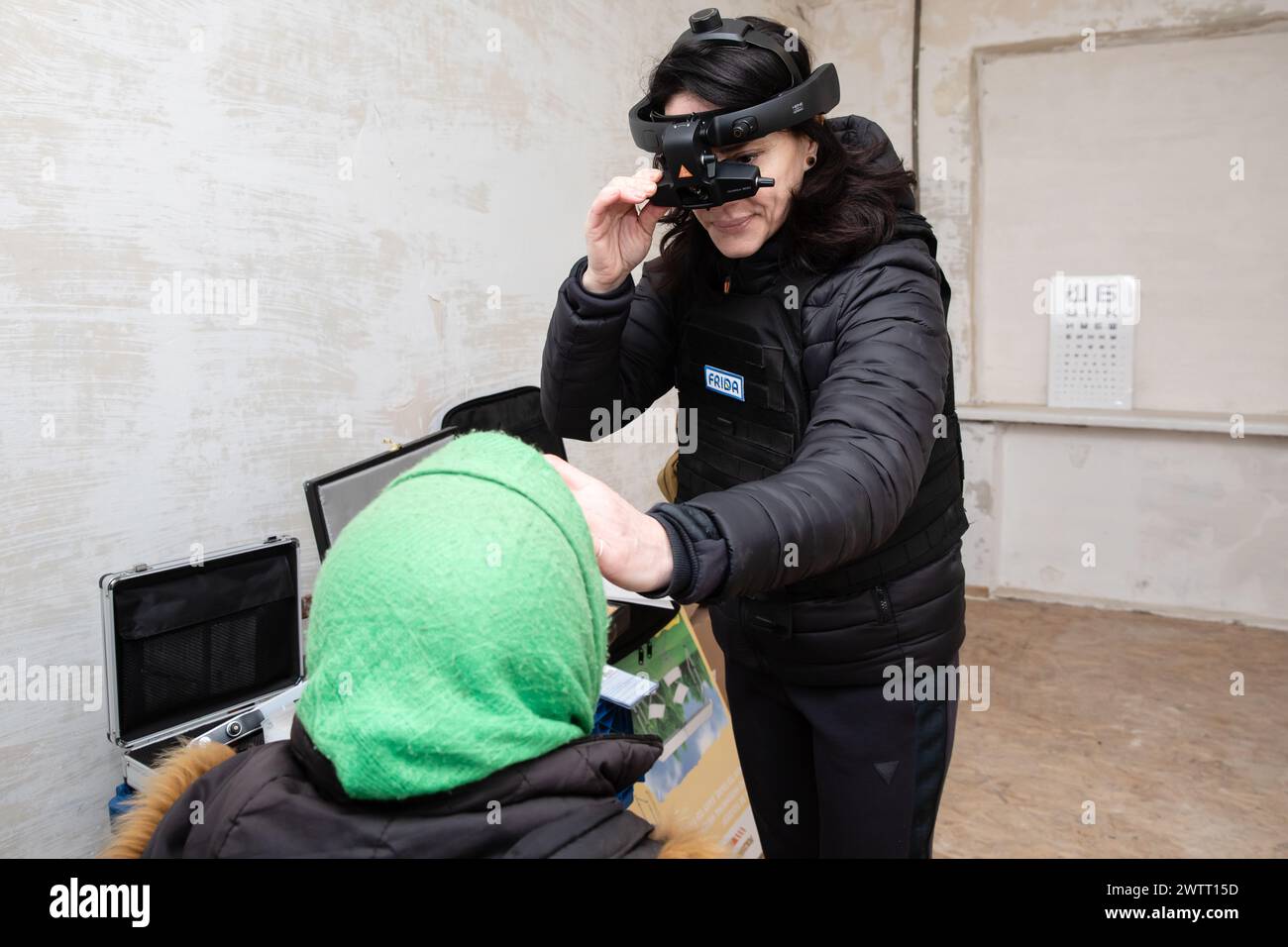 March 9, 2024, Chasiv Yar, Donetsk Region, Ukraine: A female ophthalmologist is seen examining an elderly woman using state-of-the-art mobile medical equipment. FRIDA Ukraine is a Ukrainian-Israeli mission of medical volunteers aimed at helping the population of civilians. Volunteer doctors provide Ukrainians affected by the hostilities with high quality medicine.They also organise trips to the frontline of de-occupied regions to help civilians living there. This volunteer work began in Kyiv region, followed by Chernihiv, Sumy, Kharkiv, Mykolaiv, Kherson, Donetsk and other regions where civili Stock Photo