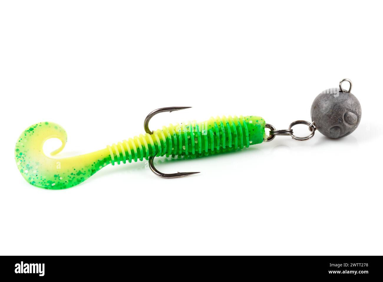 Soft fishing bait for predatory fish, green plastic grub, with double hook and lead sinker, isolated on background Stock Photo