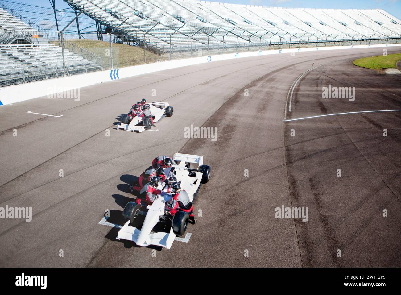 Two racing cars vying for position on a sunlit track Stock Photo