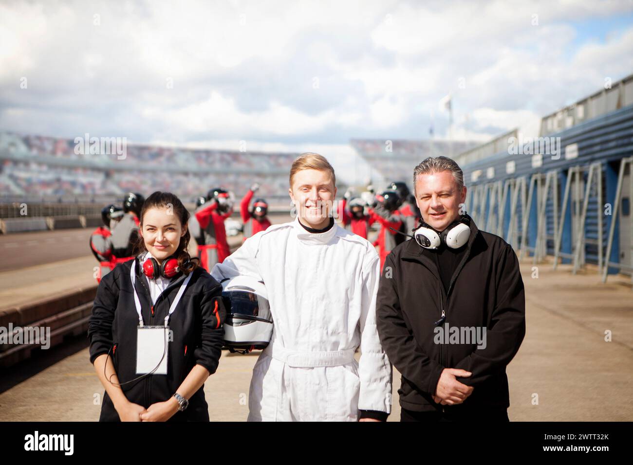 A smiling racing team ready for action on the track. Stock Photo