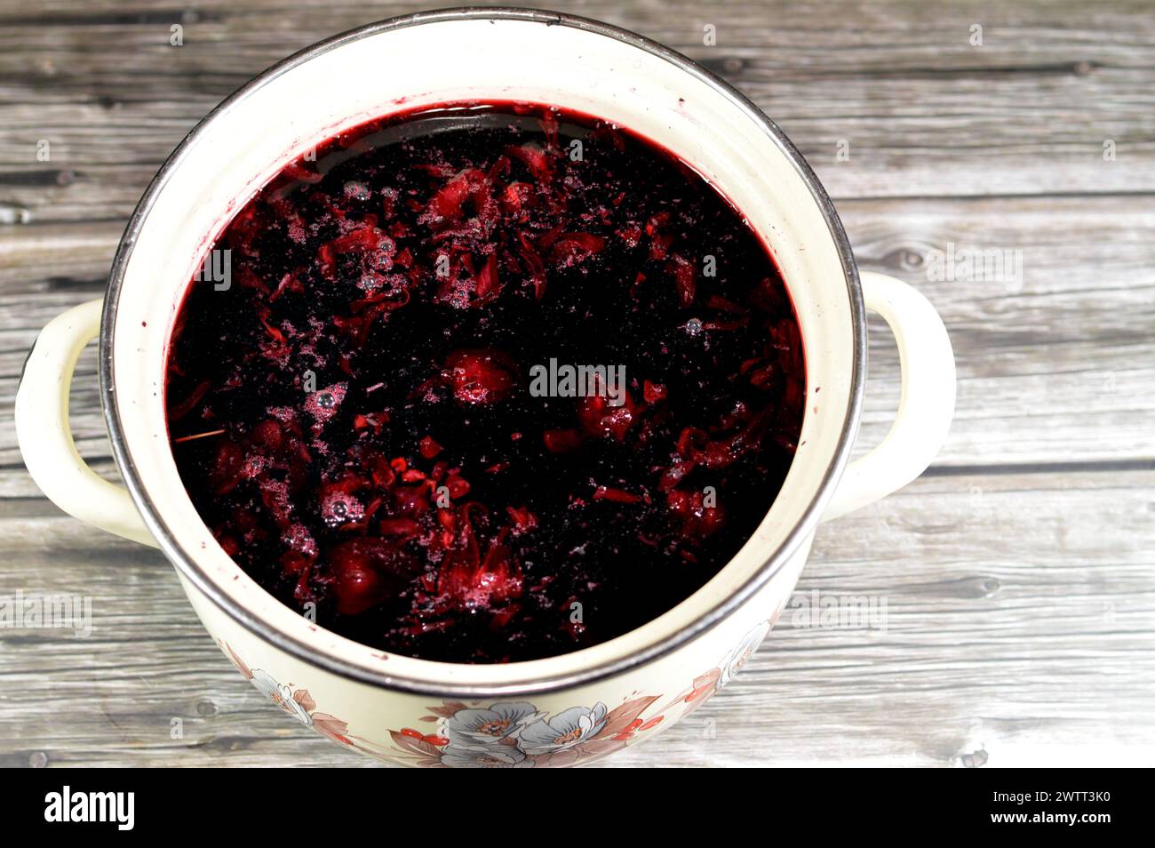 boiled roselle herbs in water, a dark red-purple colored bissap wonjo natural herbs, flowers of the Roselle plant Hibiscus used to prepare Roselle Jui Stock Photo