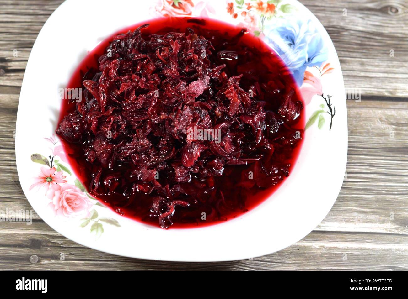 boiled roselle herbs in water, a dark red-purple colored bissap wonjo natural herbs, flowers of the Roselle plant Hibiscus used to prepare Roselle Jui Stock Photo