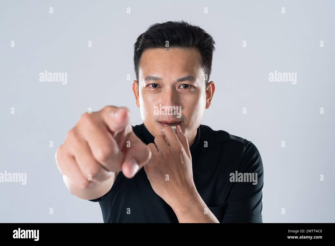 Football referee holding whistle and pointing with isolated hand on ...