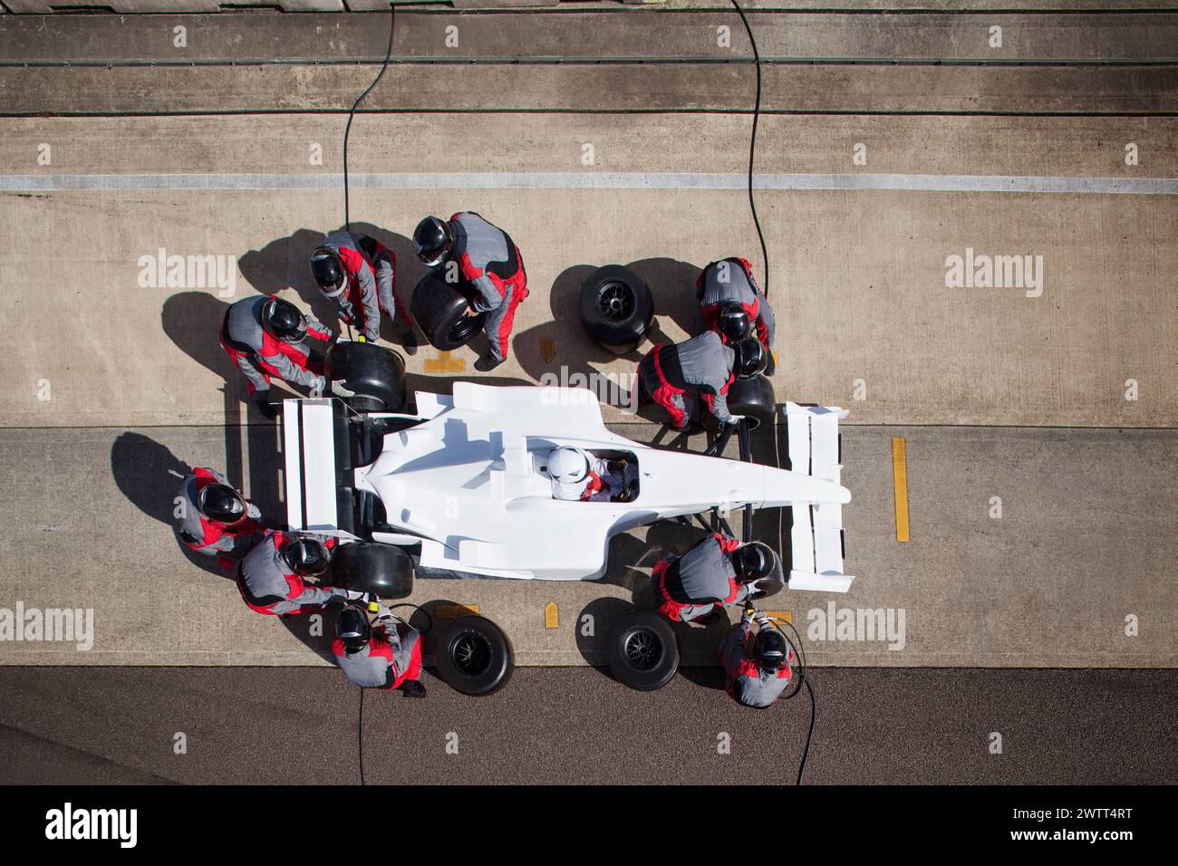 Pit stop precision teamwork in motorsport action. Stock Photo