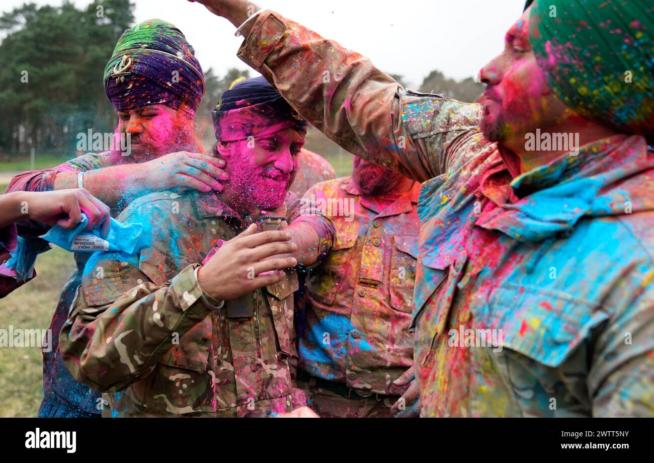 Sikh soldiers of the British Army have powdered paint thrown over them as they take part in the Holla Mahalla Sikh military festival, at the Aldershot Garrison, Hampshire. The centuries old Hola Mahalla festival celebrates Sikh martial traditions, and promotes courage, preparation, and readiness. Picture date: Tuesday March 19, 2024. Stock Photo