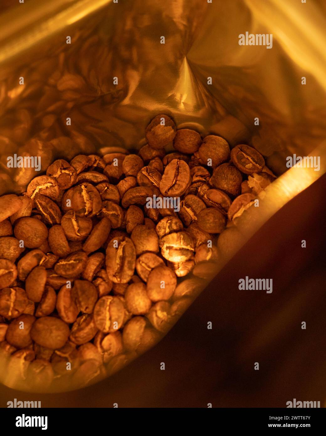 Roasted coffee beans in a brown bag on a table Stock Photo