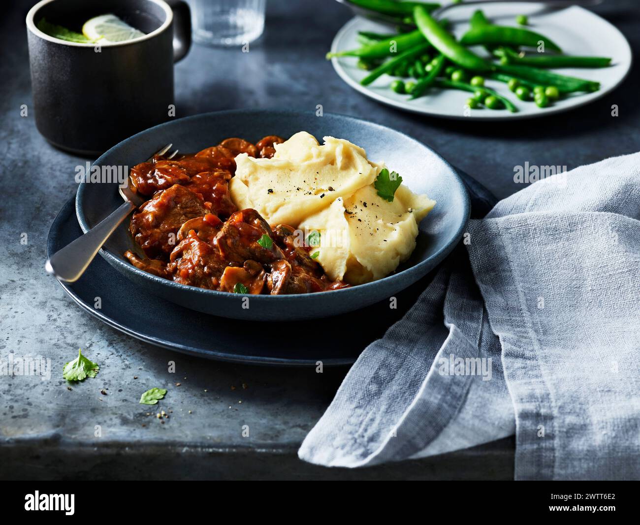 A hearty plate of beef stew with smooth mashed potatoes ready to be enjoyed. Stock Photo