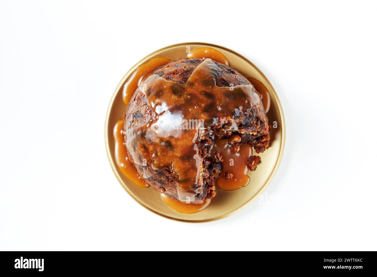 A scrumptious chocolate cake topped with gooey caramel sauce on a golden plate. Stock Photo