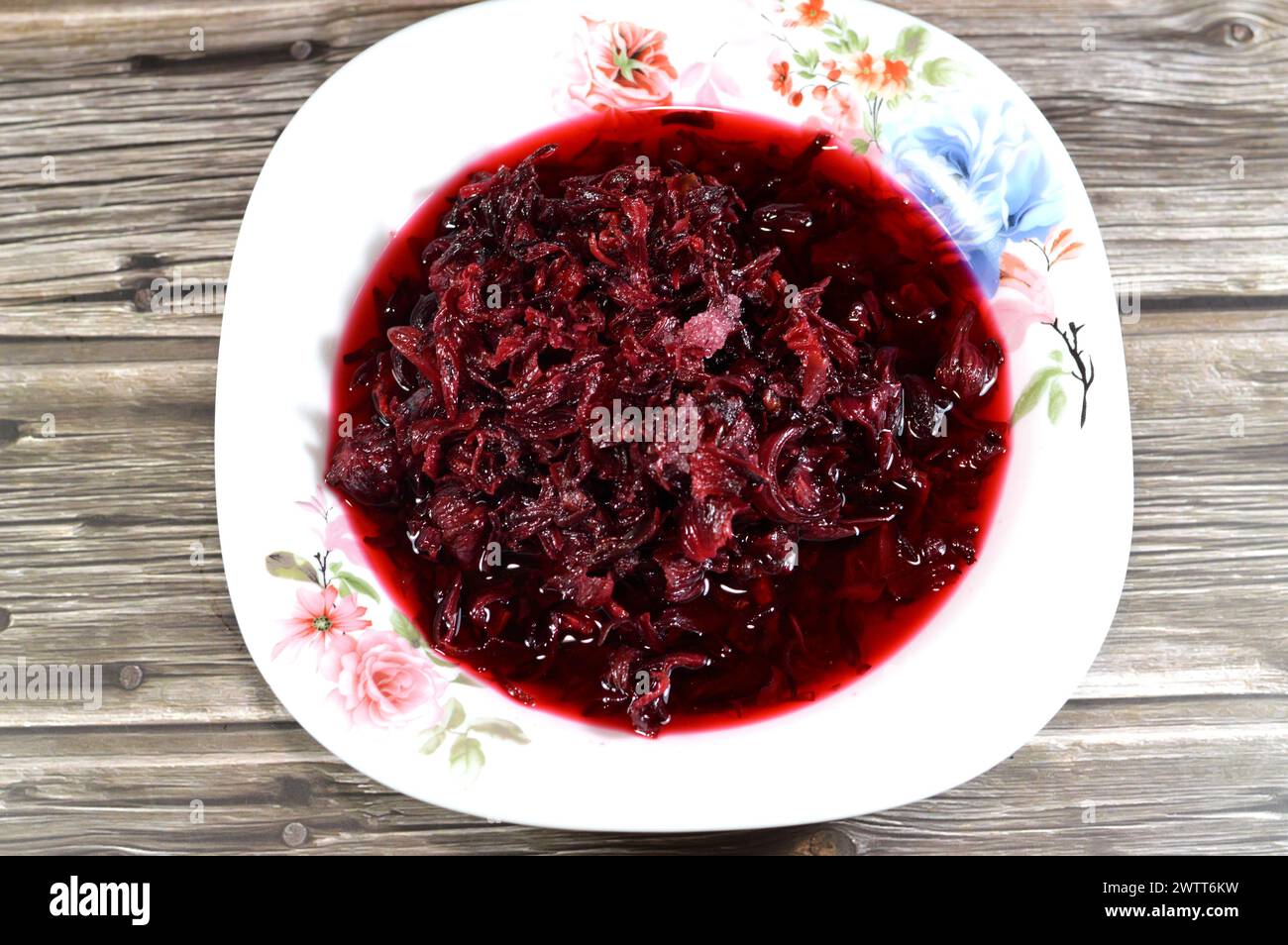 boiled roselle herbs in water, a dark red-purple colored bissap wonjo natural herbs, flowers of the Roselle plant Hibiscus used to prepare Roselle Jui Stock Photo