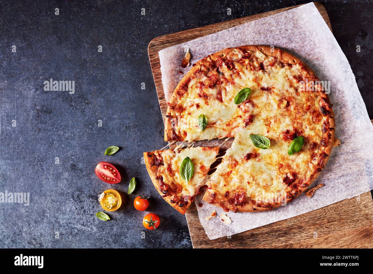 A delectable cheese pizza with a slice being served Stock Photo