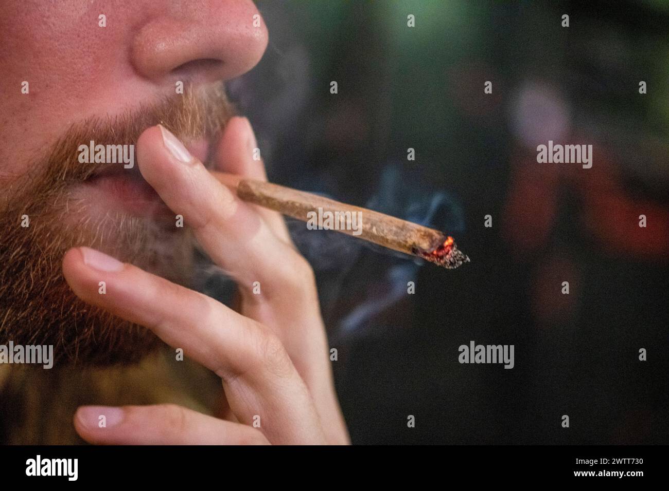 Closeup of a person smoking a rolled cigarette Stock Photo