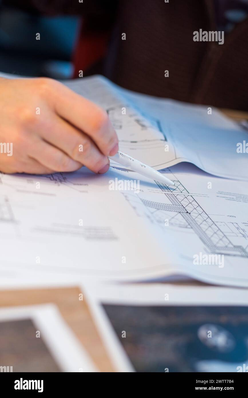 A focused moment captured as a hand sketches architectural designs on paper. Stock Photo